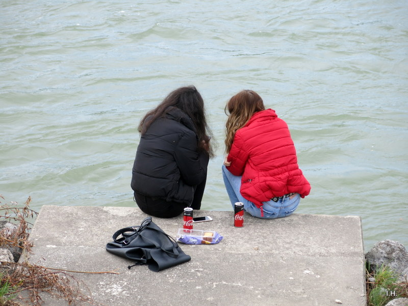 zwei Mädchen sitzen am Ufer